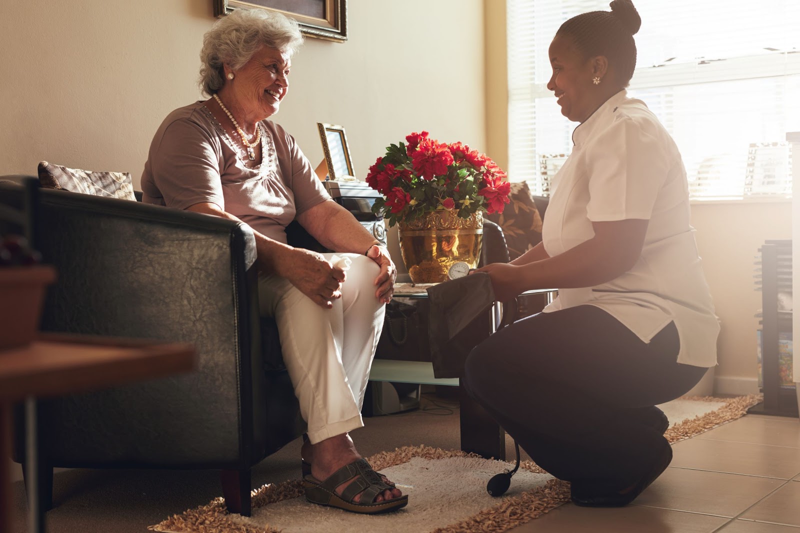 A home health care worker assists her elderly client
