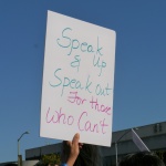 sign that says speak up and speak out for those who can't