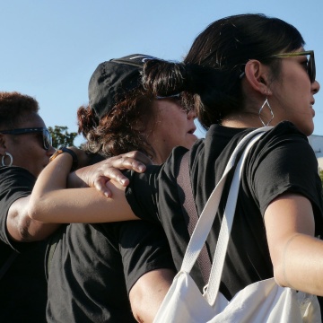 Women link arms at a protest/rally in solidarity