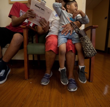 Mo and two kids sitting in a waiting room