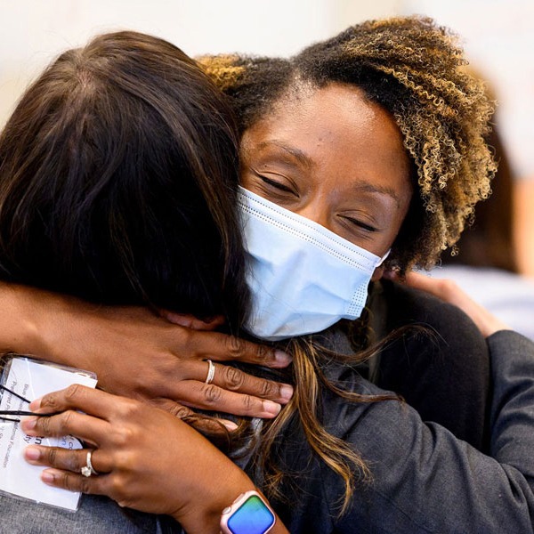 Two women embrace, mood is warm and affirming